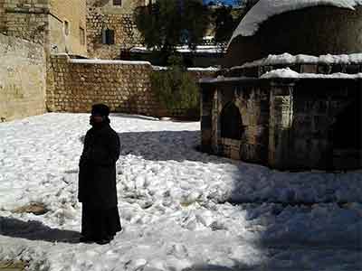 An Ethiopian monk surprised by the heap of snow near his cell on the roof of the Holy Sepulchre Dec 2013